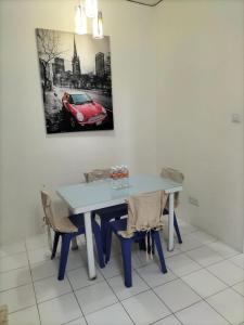 una mesa de comedor con una pintura de coche rojo en la pared en Upper Sanctuary, en Kuching