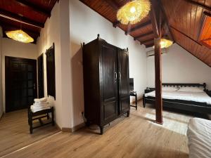 a bedroom with two beds and a large cabinet at La Conac in Nufăru
