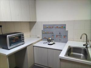 a kitchen with a sink and a microwave on a counter at Upper Sanctuary in Kuching