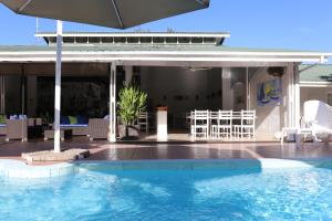 einen Pool mit Sonnenschirm und Stühlen in der Unterkunft Residence Argine in Victoria