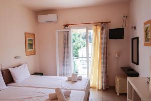 um quarto de hotel com duas camas e uma janela em Al Mar 2 em Skiathos
