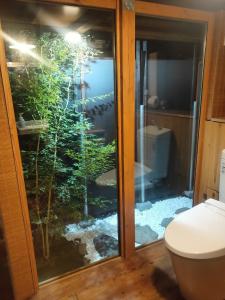 a bathroom with a fish tank inside of a toilet at Momiji hostel in Minami Aso