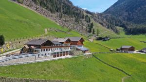 una vista aérea de una gran casa en una colina en Roanerhof, en Campo Tures