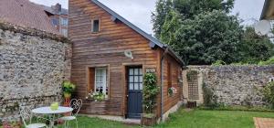 uma casa de madeira com uma mesa num quintal em Honfleur à deux em Honfleur