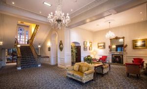 a large lobby with a chandelier and a staircase at Grand Hotel in Malahide