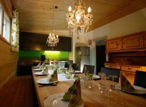 une salle à manger avec une grande table, des chaises et un lustre dans l'établissement Haus Rose, à Schröcken