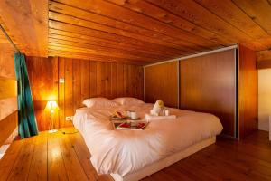 - une chambre avec un grand lit et un plafond en bois dans l'établissement Résidence Grand Roc - Studio 708 - Happy Rentals, à Chamonix-Mont-Blanc
