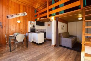 Il comprend une cuisine et un salon avec une table et un canapé. dans l'établissement Résidence Grand Roc - Studio 708 - Happy Rentals, à Chamonix-Mont-Blanc
