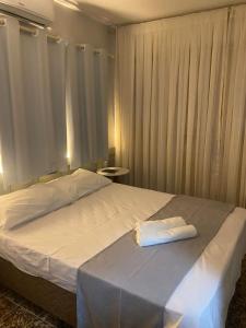 a bedroom with a bed with a towel on it at Hotel Casa Blanca in Mossoró