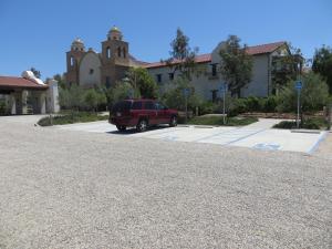 a red suv parked in a parking lot in front of a building at Ponte Vineyard Inn in Temecula