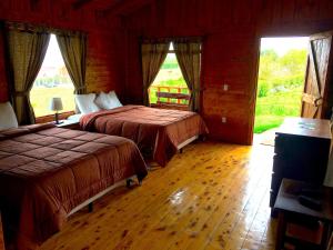 una camera da letto con due letti e una grande finestra di Grandpas Hotel & Restaurante a Cartago