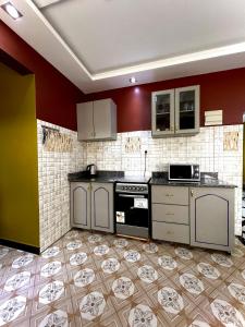 a kitchen with white cabinets and a tile floor at Malaika courts in Kampala