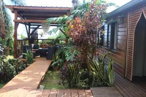 - un jardin avec une passerelle en bois à côté d'une maison dans l'établissement LA LIANE DE JADE 974-Lodge Le Palissandre - jacuzzi privatif - piscine, à Le Bois de Nèfles