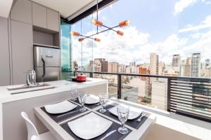 een keuken met een eettafel en een groot raam bij 360 VN Capote Valente by Housi in Sao Paulo