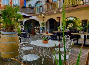 an outdoor patio with tables and chairs and plants at L'Ecume des Jours in Soulac-sur-Mer