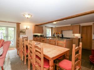 a large kitchen with a wooden table and chairs at Timber Barn in Eardisland