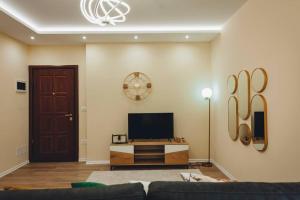 ein Wohnzimmer mit einem Sofa und einem TV in der Unterkunft Luxury Apartment at Myslym Shyri in Tirana