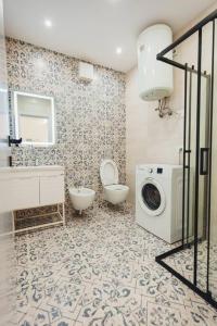 ein Badezimmer mit einem WC und einer Waschmaschine in der Unterkunft Luxury Apartment at Myslym Shyri in Tirana