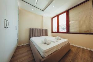 a bedroom with a bed with two towels on it at Luxury Apartment at Myslym Shyri in Tirana