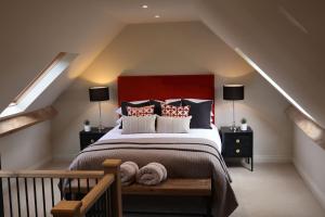 a bedroom with a large bed with a red headboard at Piglet's Hideaway in Stratford-upon-Avon