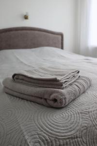uma pilha de toalhas sentadas em cima de uma cama em Skalvija Apartment Dreverna em Dreverna