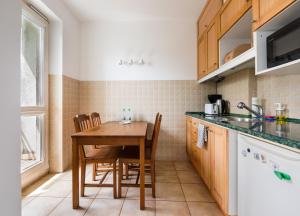 a kitchen with a table and chairs in a room at Rondo Szendzielarza Standard Studio in Warsaw