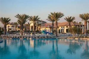 uma grande piscina com palmeiras e edifícios em Spacious 8BR Villa by Disney World w Private Pool em Kissimmee