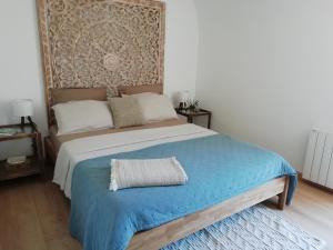1 dormitorio con 1 cama con manta azul en A Torra, en Ville-di-Paraso