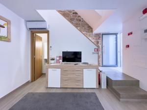 an attic room with a desk and a tv at Casa das Flores in Oliveira do Hospital