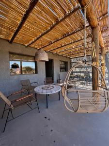 een patio met een tafel en stoelen en een schommel bij Casa Vergara 3 in Villa Unión
