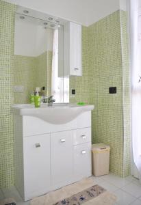 y baño con lavabo blanco y espejo. en Casa Vacanza M.V., en Bérgamo