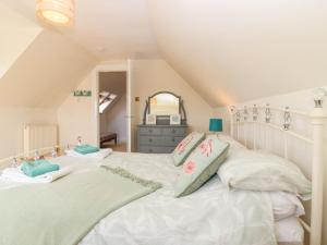 ein Schlafzimmer mit einem großen weißen Bett mit Kissen in der Unterkunft Old Cooperage in Port Erroll