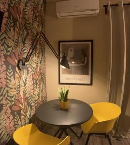 a table and two yellow chairs in a room at Kalasó Design Guest House in Fiumicino