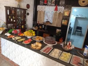 a buffet with many different types of food on it at Pousada Casa Jardim in Serra Negra