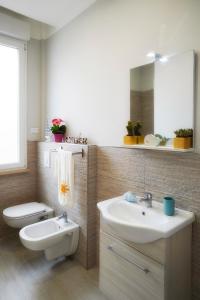 bagno con lavandino, servizi igienici e specchio di Residence Deamarina a Marina di Massa