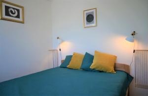 Schlafzimmer mit einem Bett mit blauen und gelben Kissen in der Unterkunft Rose Hill 4 in Budapest