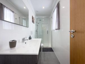 a white bathroom with a sink and a shower at Casa das Flores in Oliveira do Hospital +12 photos