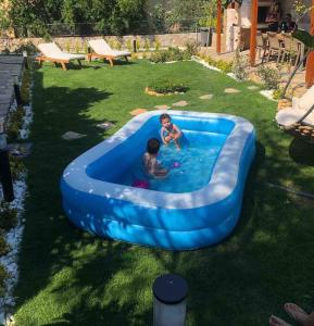 two children playing in a blue tub in a yard at VillaAnforaSelimiye in Selimiye