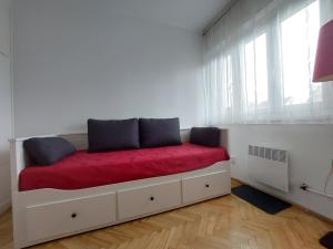 Schlafzimmer mit einem Bett mit roter Bettwäsche und Fenstern in der Unterkunft Rose Hill 4 in Budapest