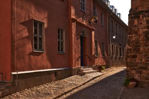 eine Gasse in einer Altstadt mit roten Gebäuden in der Unterkunft Pension Alter Bischofshof in Naumburg