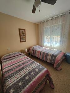 1 dormitorio con 2 camas y ventana en Chalet Chilches Costa 1ª linea PLAYA, en Vélez-Málaga