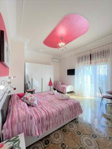 een slaapkamer met 2 bedden en een groot roze plafond bij Il Borgo in Agerola