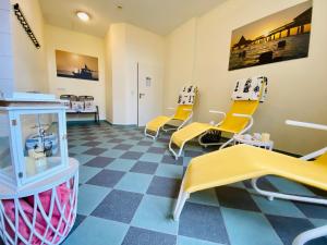 a waiting room with yellow chairs and a basketball hoop at Residenz Bleichröder - Ferienwohnung 11 in Heringsdorf