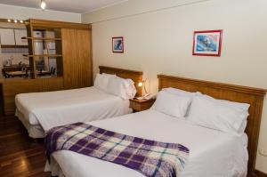 a hotel room with two beds and a telephone at Altezza Apart Suites in Mendoza +30 photos
