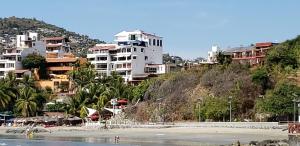 a group of buildings on a hill next to a beach at Vista Bahia Zihua in Zihuatanejo
