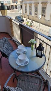 niebieski stół na balkonie z kubkami i spodkami w obiekcie Reis Turismo w Faro