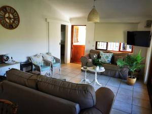 ein Wohnzimmer mit einem Sofa und einem Tisch in der Unterkunft Sipreslaan Selfsorg Gastehuis in Ladismith