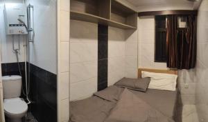 een kleine kamer met een bed en een toilet bij Tsim Sha Tsui Bedrooms in Hong Kong
