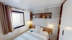 une petite chambre avec un lit et une fenêtre dans l'établissement Mobil home 4/6 personnes, à Seignosse 13 autres photos