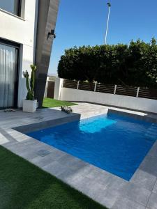 uma piscina azul em frente a uma casa em Brilliant Villa em Gran Alacant